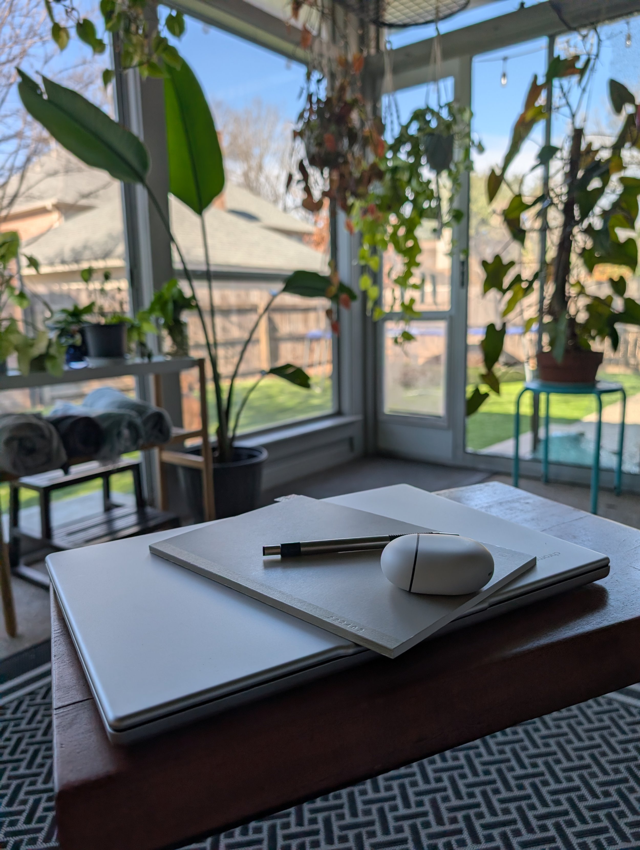 A sunlit indoor garden workspace with a laptop and notebook, symbolizing the calm and intentional habit coaching approach of Pockets of Progress.