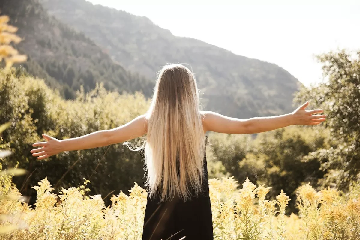 Woman with arms open to the sky.
