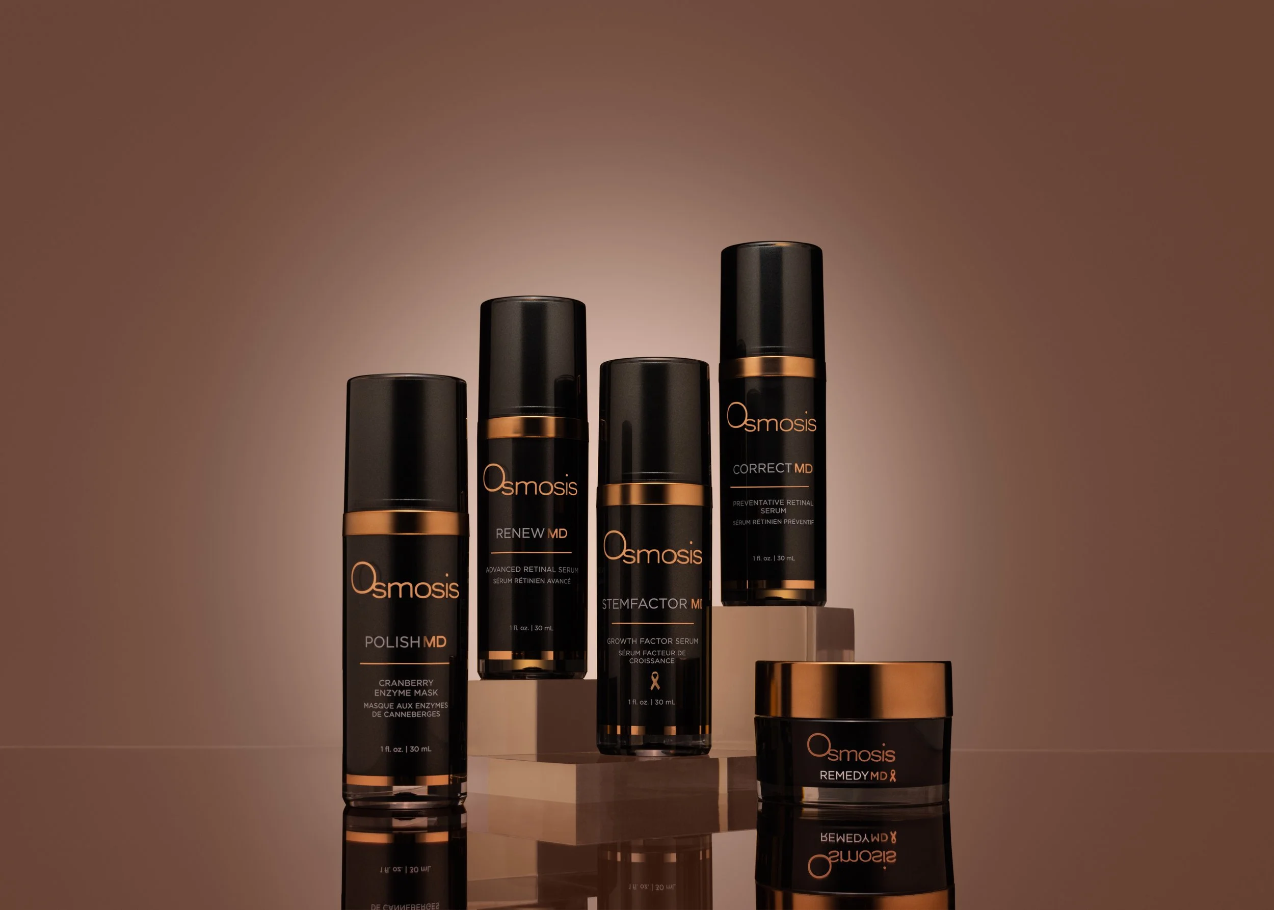 Osmosis skincare products, including Polish MD, Renew MD, StemFactor MD, Correct MD, and Remedy MD, displayed on reflective blocks.