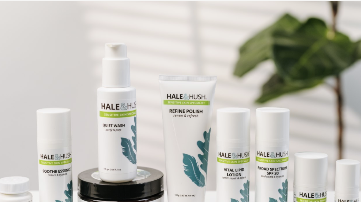 Hale & Hush sensitive skin care products arranged on a countertop, including cleanser, exfoliating polish, lotion, sunscreen, and serums.