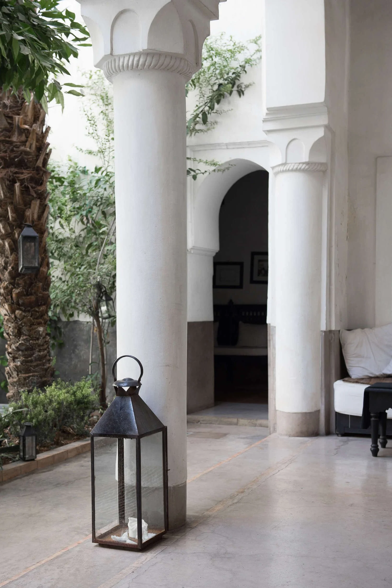 Peaceful outdoor courtyard with white stone columns and black lantern