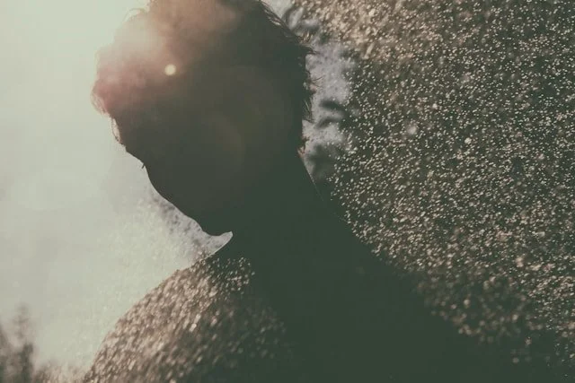 Silhouette of a woman against sunlit bokeh.