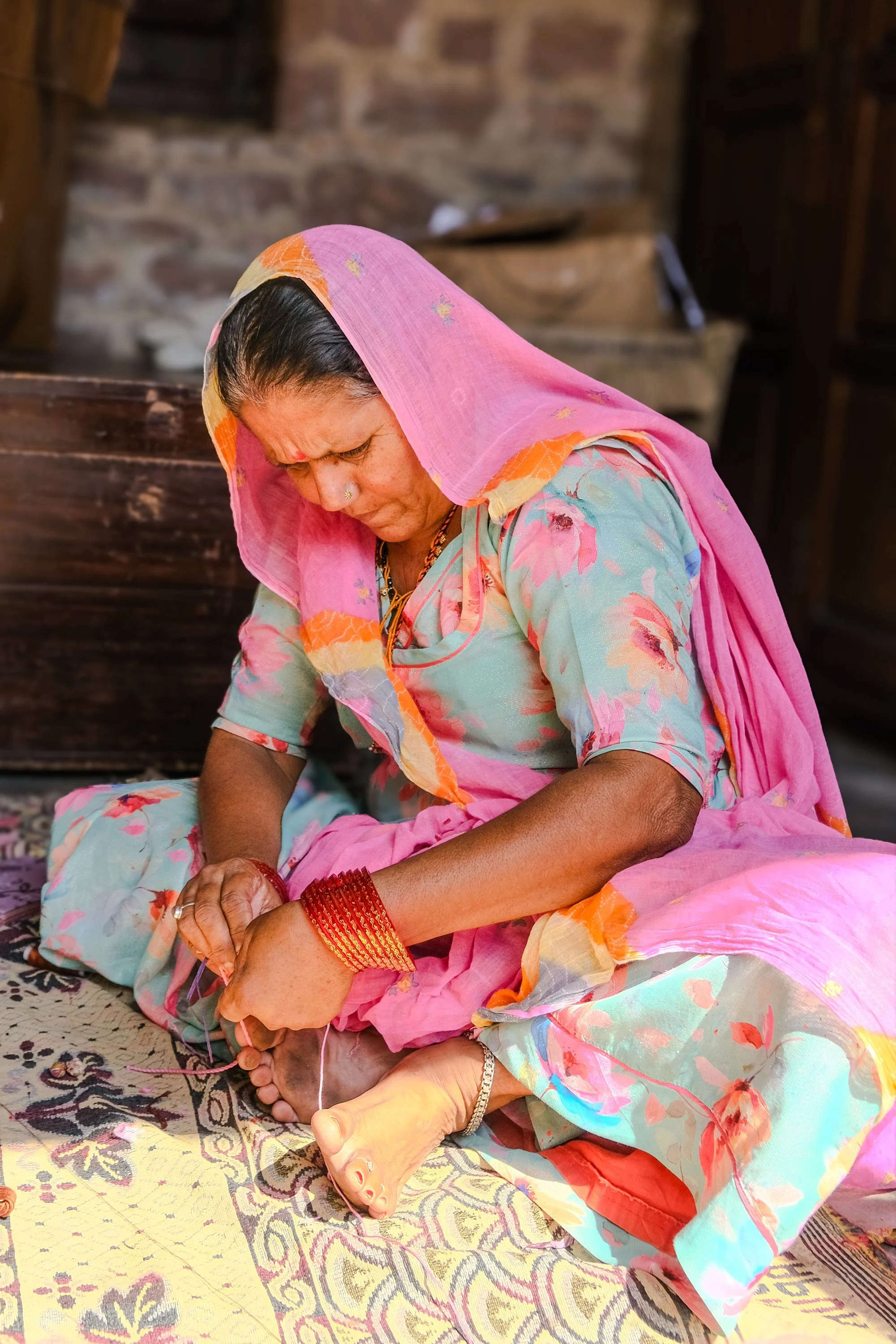 Woman artisan hand-sewing traditional beadwork at Sunder Rang, Chandelo near Jodhpur, Rajasthan