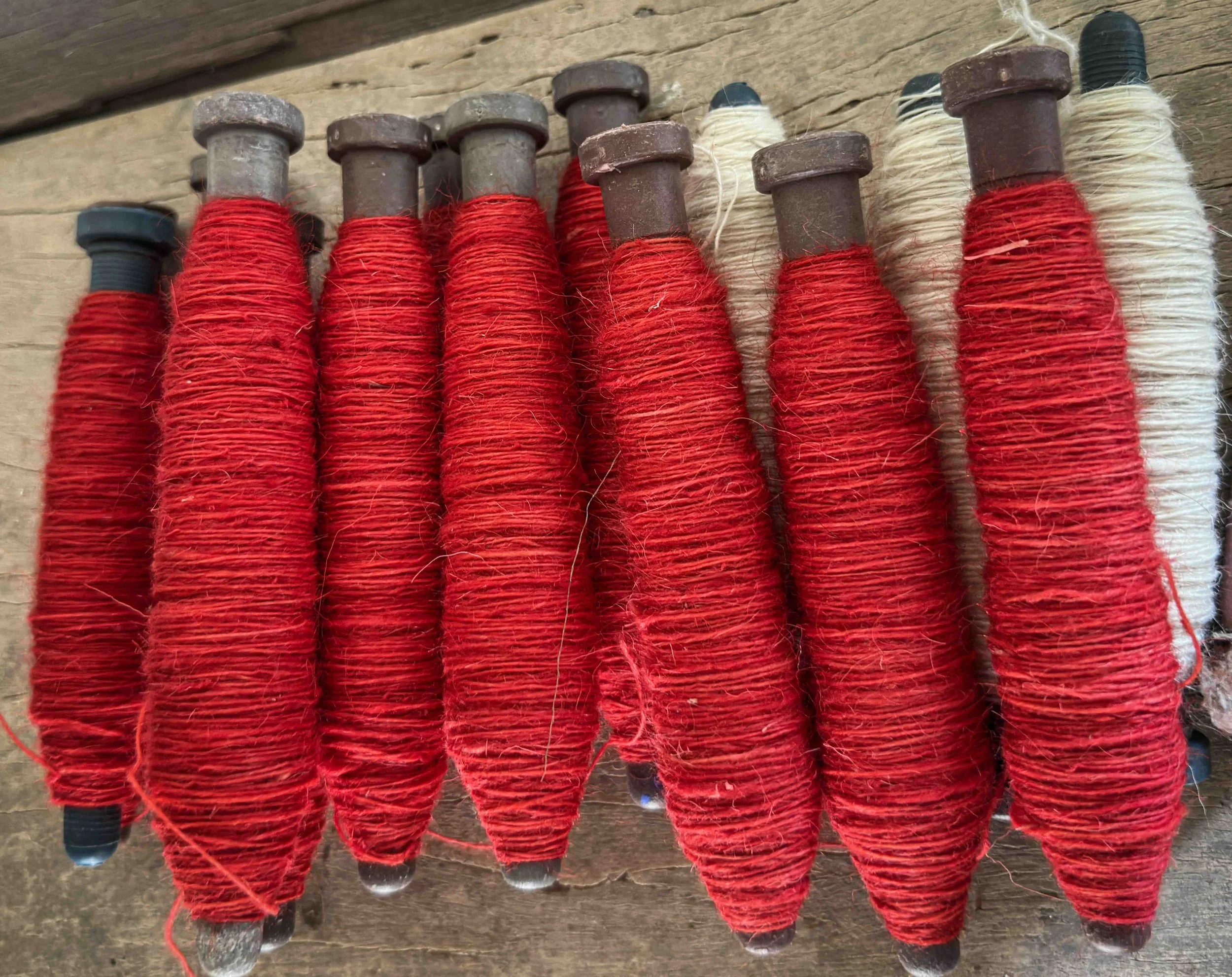 Red and white thread-wound wooden bobbins for handloom weaving, Rajasthan — India with Bernadette