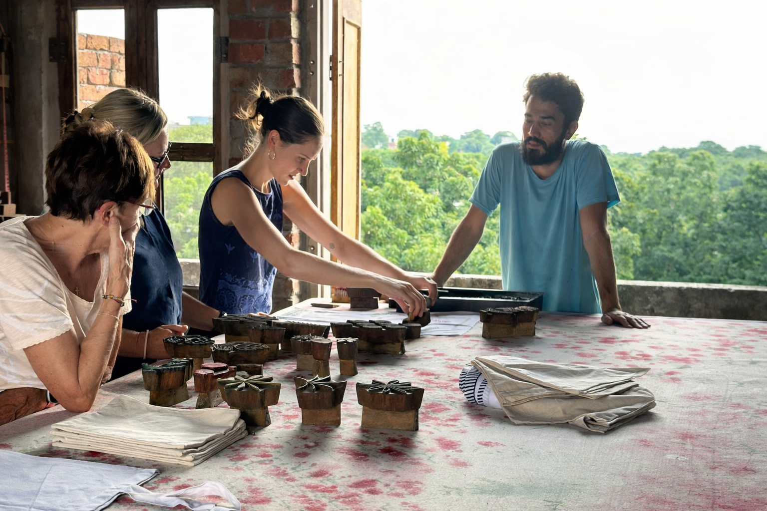 Travellers learning traditional block printing with wooden stamps in a Jaipur artisan workshop, Rajasthan