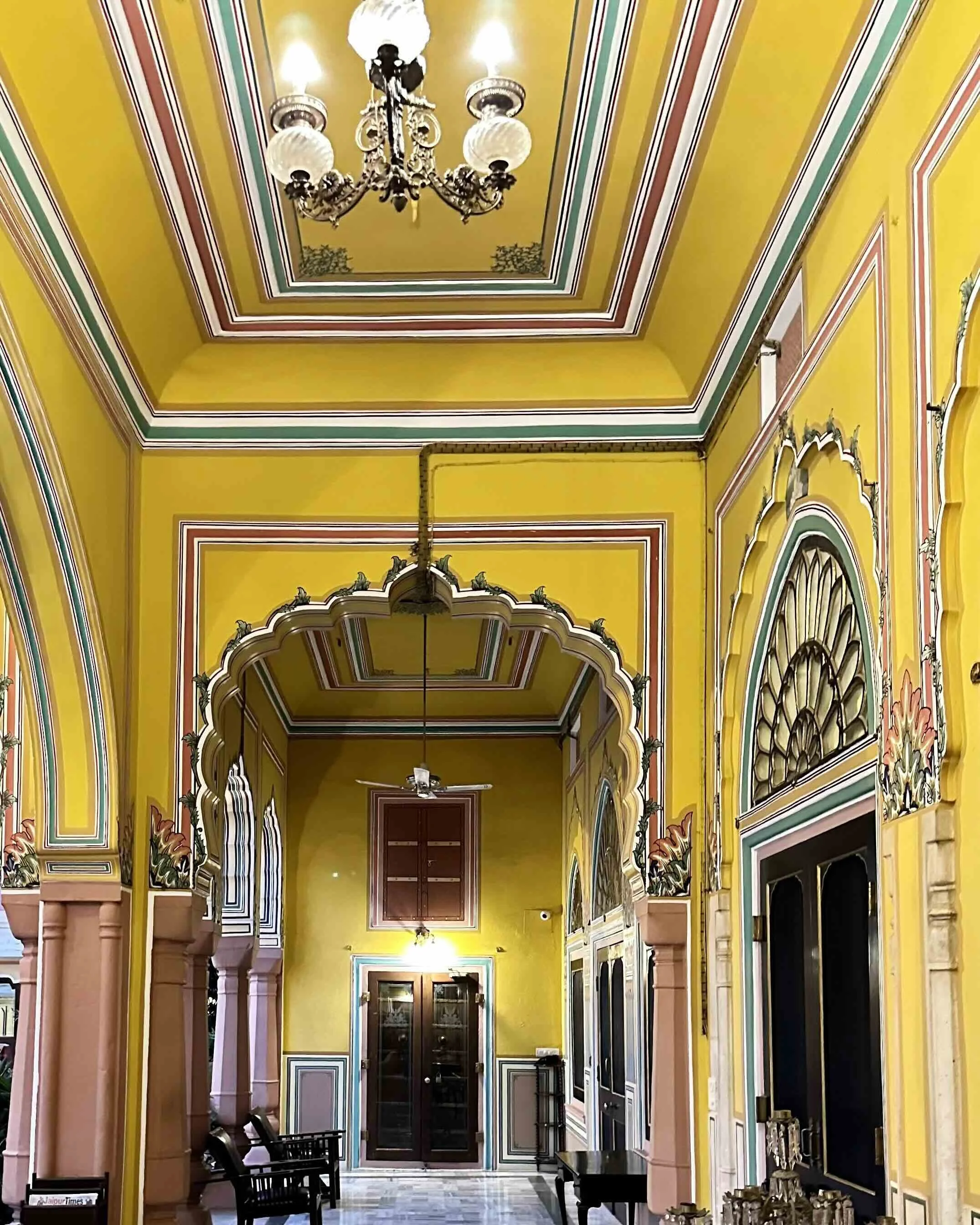 Painted yellow veranda with ornate arched entrance at Narain Niwas Palace heritage hotel, Jaipur, Rajasthan-India with Bernadette