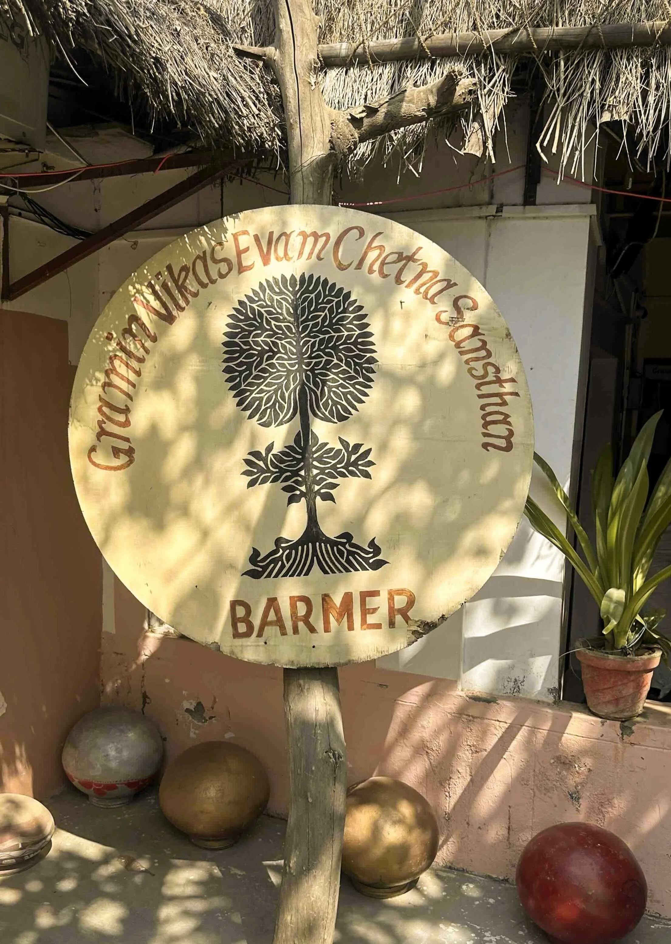 Circular GVCS logo sign at the entrance to the Gramin Vikas Evam Chetna Sansthan compound, Barmer, Rajasthan