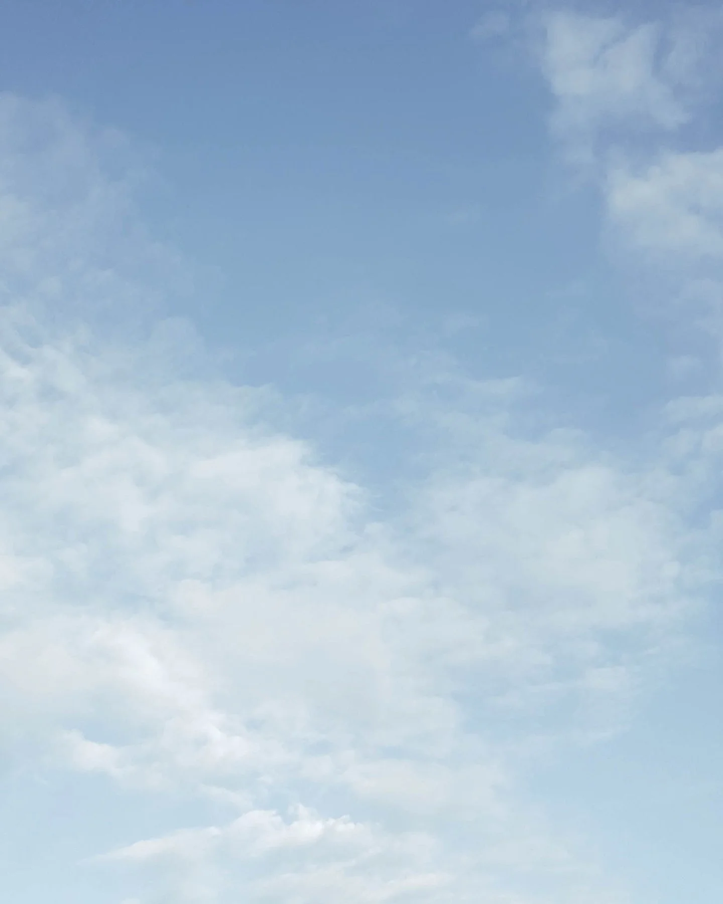 A clear blue sky with some light, white clouds.