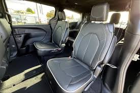 Interior of a vehicle showing front and middle seats with black upholstery.