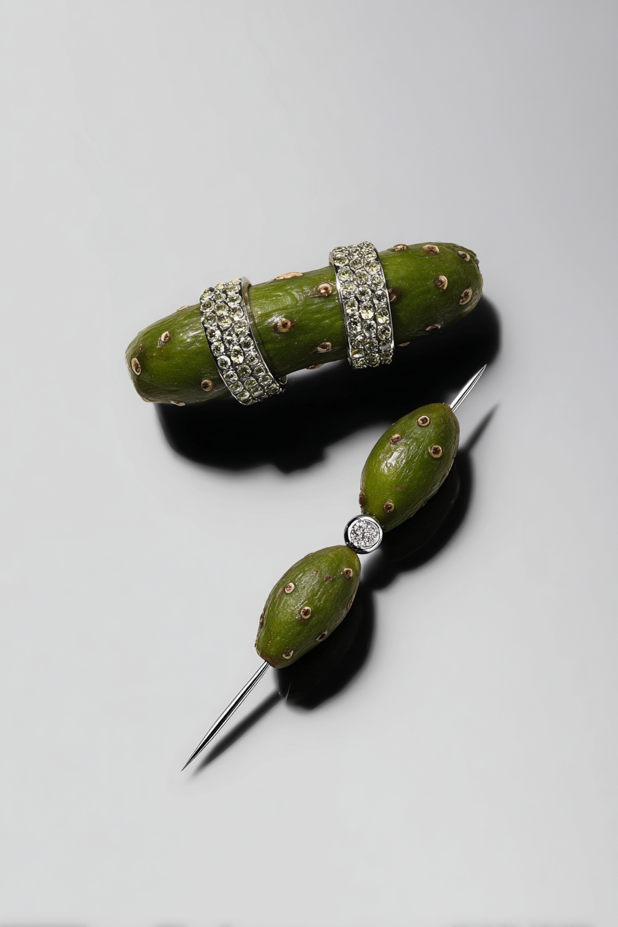Green cactus with rhinestone rings and a diamond ring on a sewing pin.