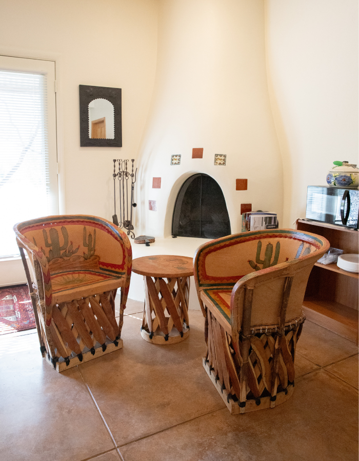 Leather equipale chairs next to a decorative beehive fireplace in the Arizona Lounge at The Lodge
