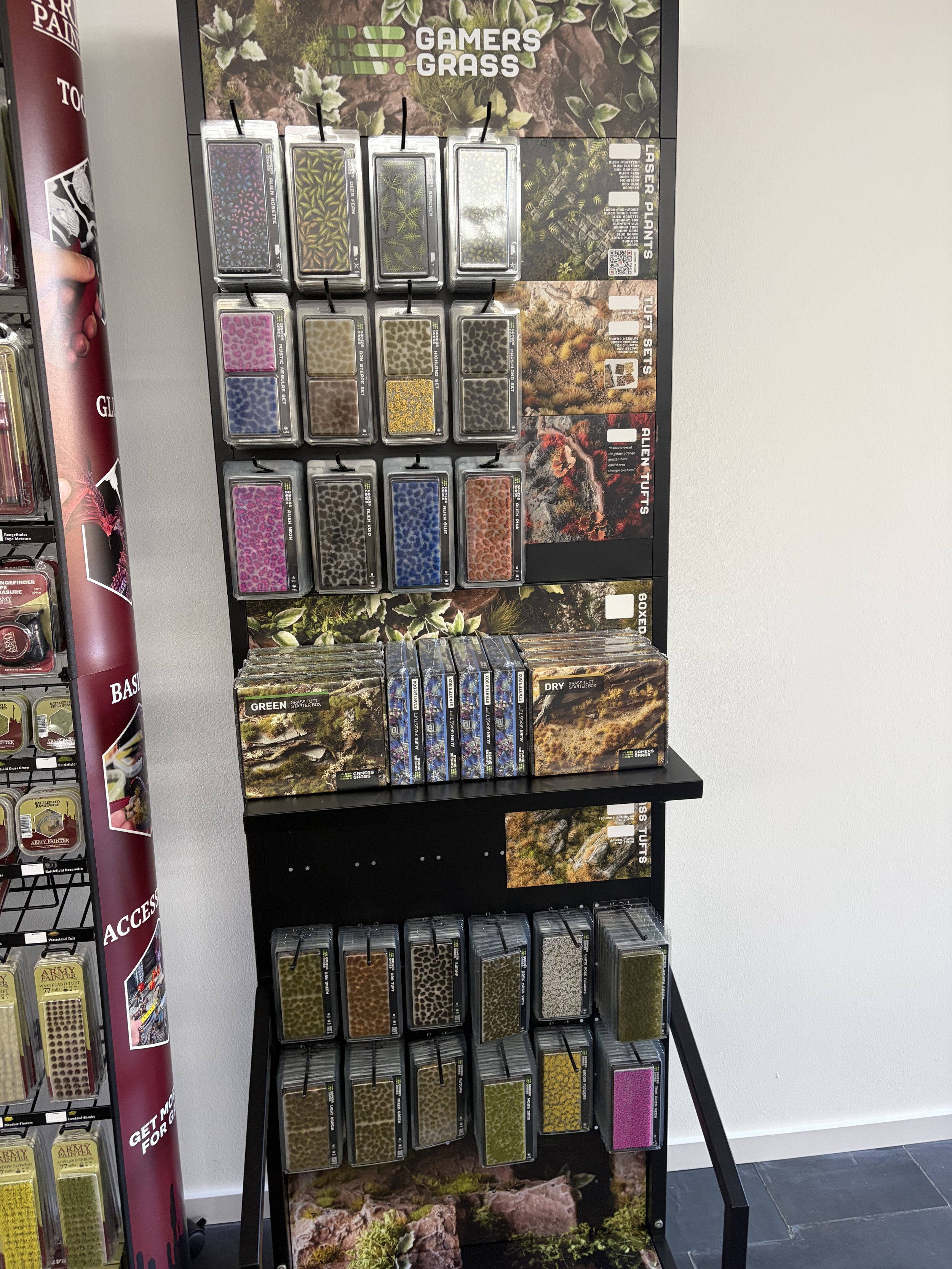 Auswahl an Miniaturplänen und Saatgut für invasive Pflanzenarten, die in einem Gartencenter aufgestellt sind.