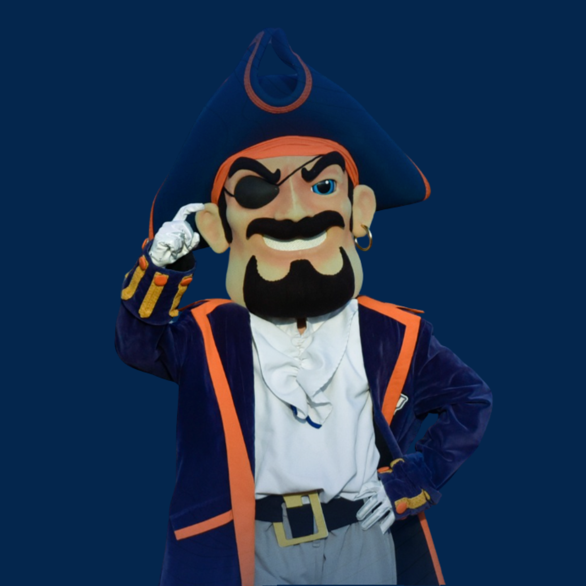 A person in a pirate costume with a large pirate head mask, an eye patch, and pirate attire, posing with one hand on his hip against a dark background.