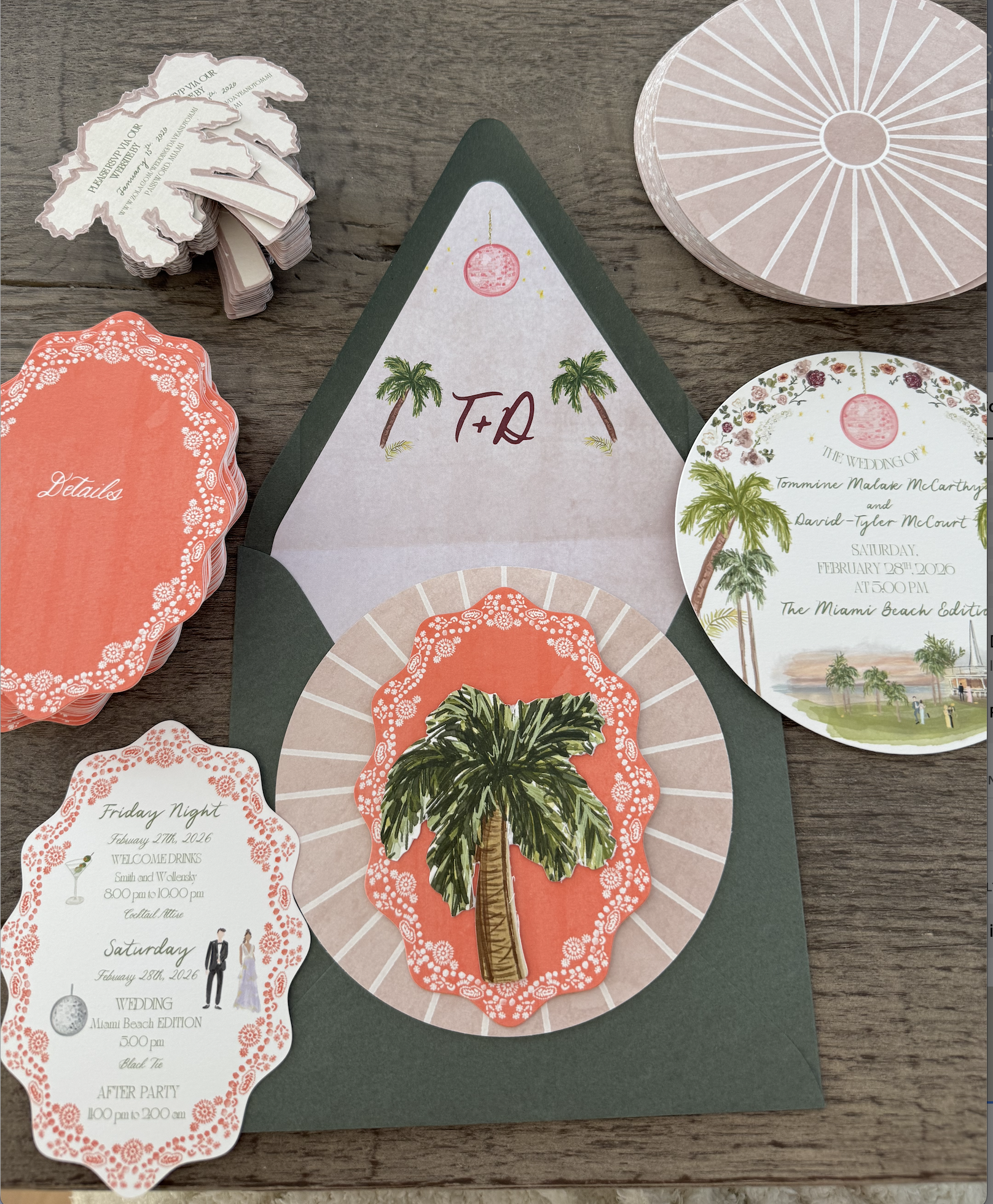 Wedding invitation stationery set with tropical theme, including a dark green envelope, round and scalloped RSVP cards with palm tree illustrations, and a sticker with a palm tree. The cards feature pink and green tropical motifs and event details.