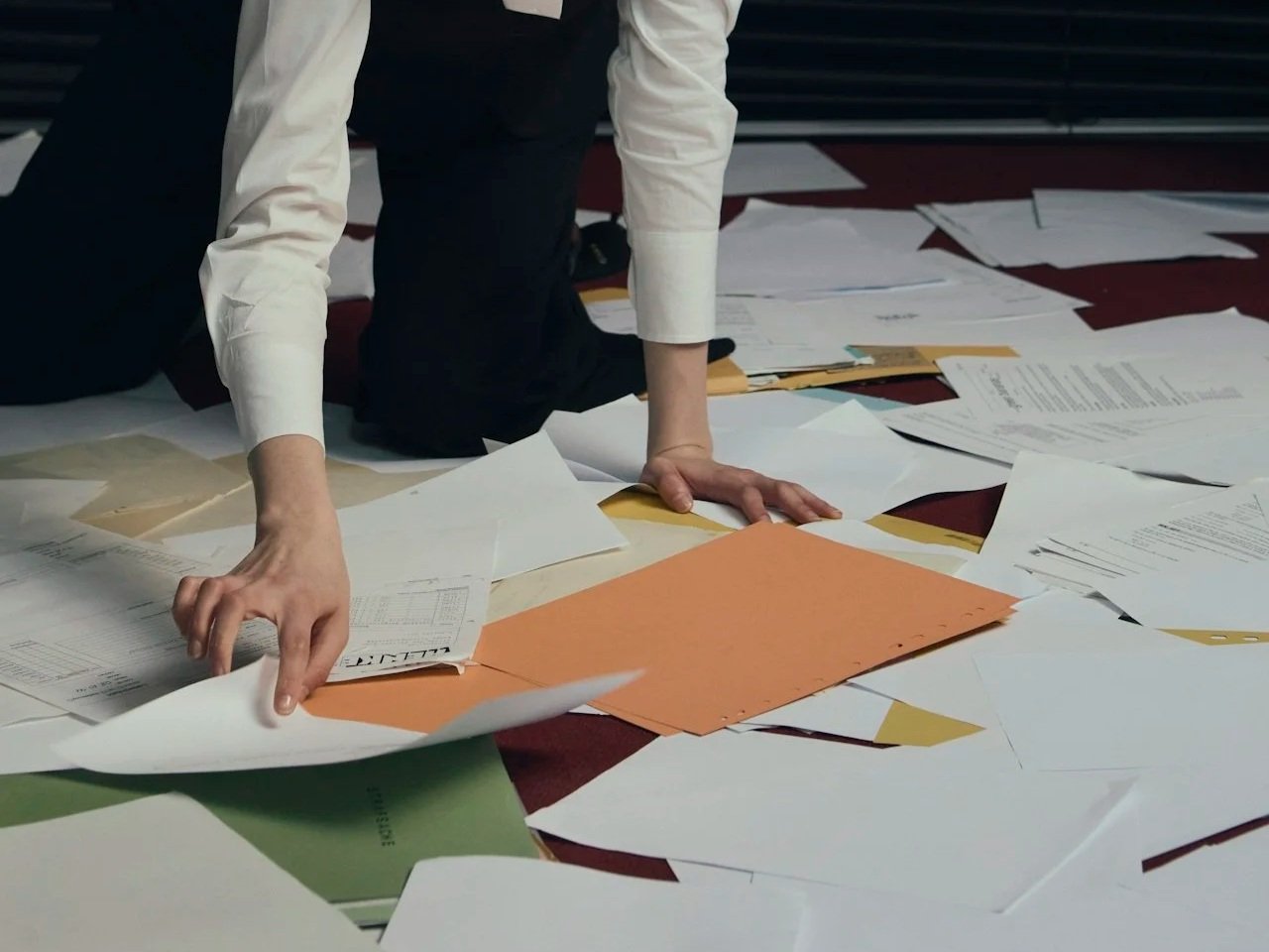 Woman collecting papers on the floor