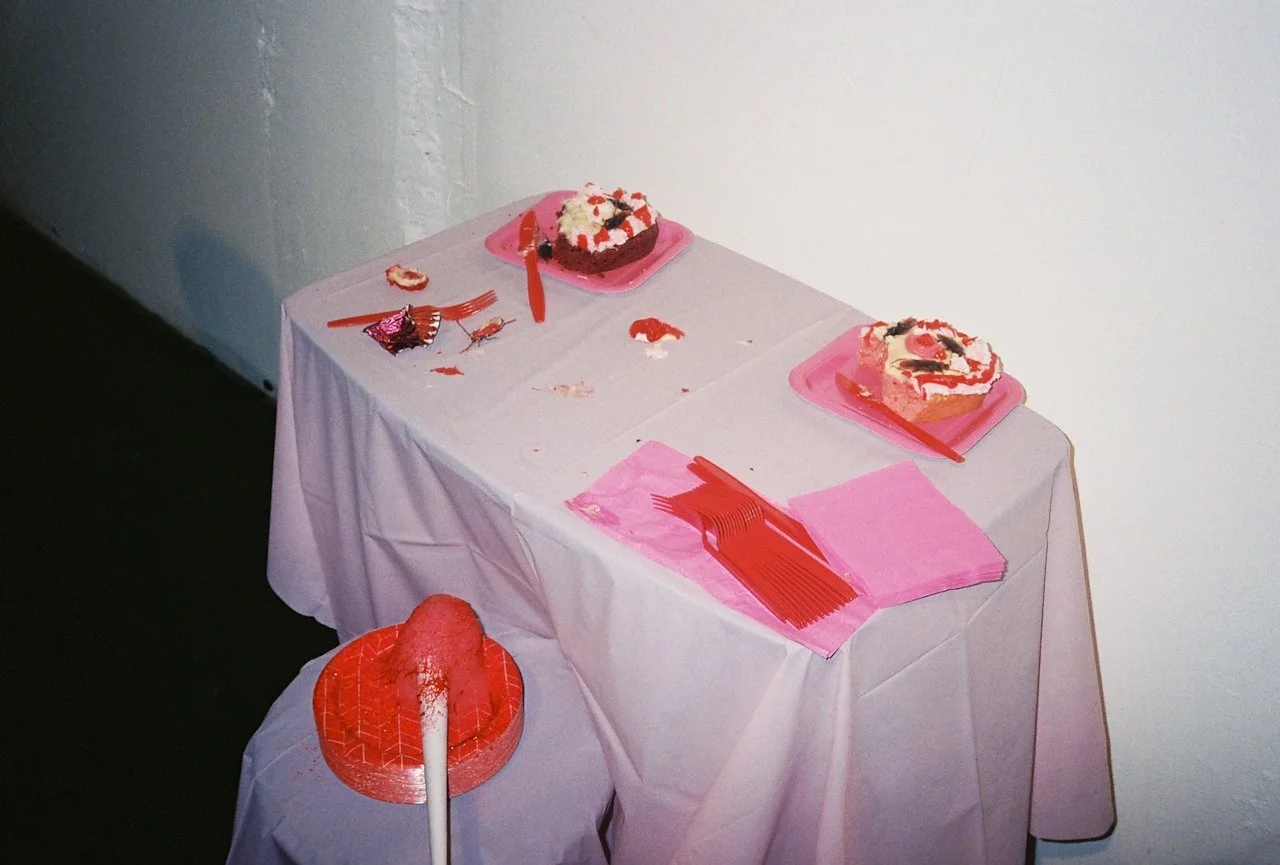 A table with pink plates, cakes, cups, and party hats is ready for the event—perfect for your Squarespace calendar photos.