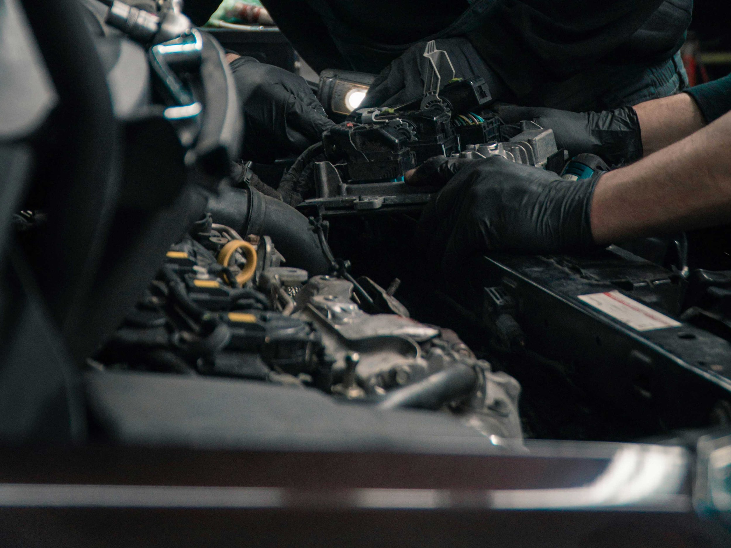 Mechaniker arbeitet am Motor eines Fahrzeugs in einer KFZ Werkstatt in Schwerin