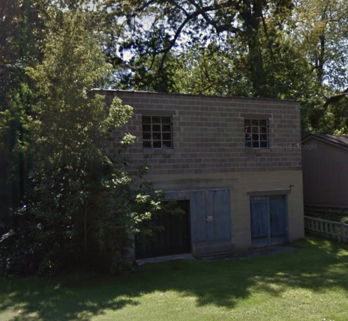 Before - Lake Drive - nineteen fifty-one concrete block built for a corner store, turned dusty storage -- forty-five years empty till MichaelAngela Properties claimed it.