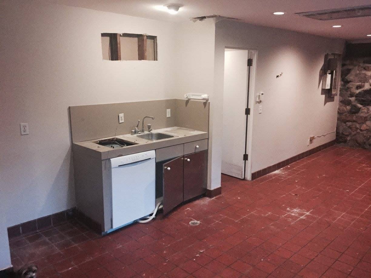 A dog kennel interior, dirty and empty, used for housing animals. 