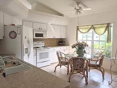 Before: Dated 1990's kitchen with cramped layout and limited countertop space, old acrylic PVC lights, and a poorly positioned refrigerator. 