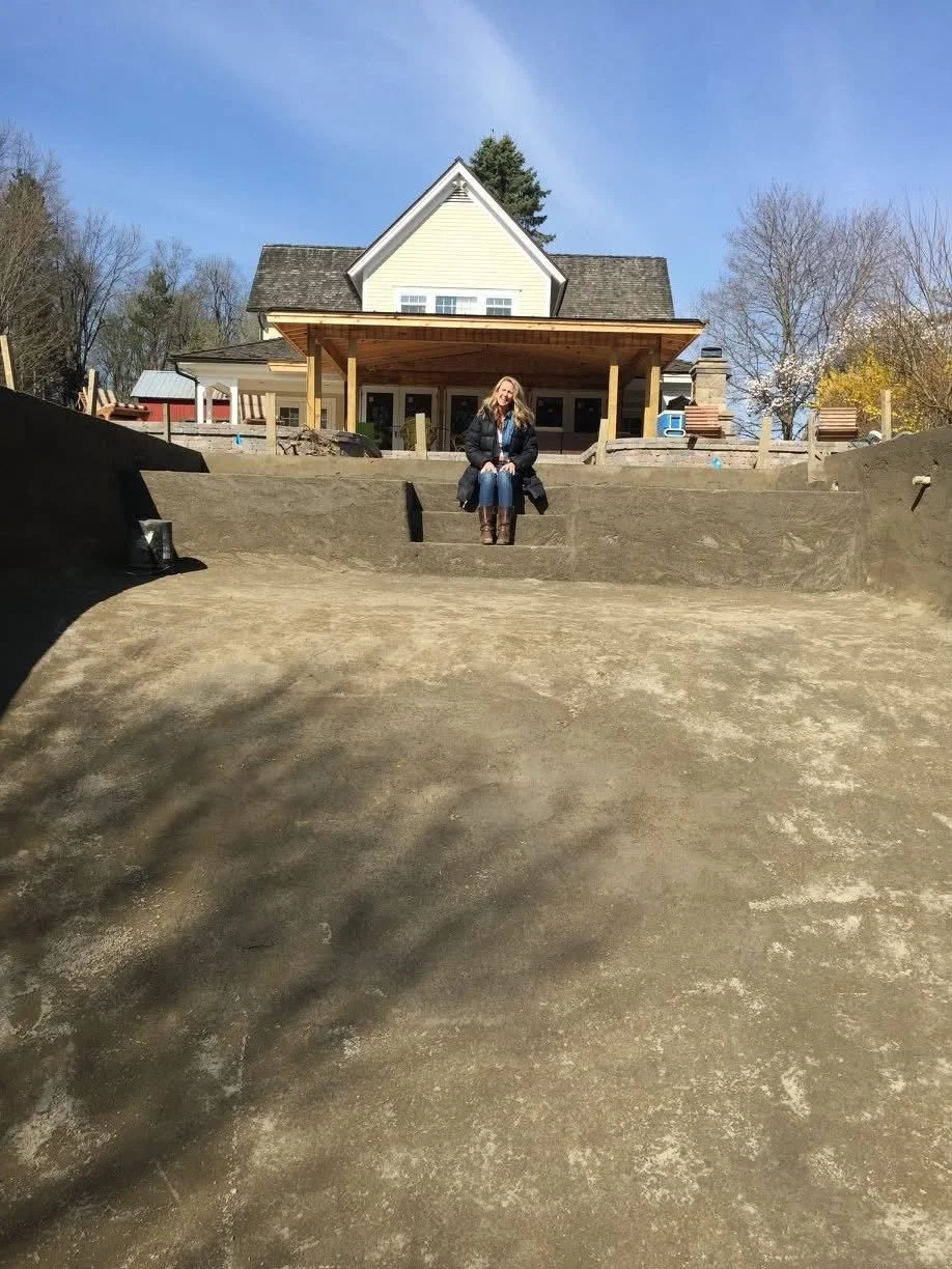 Transformation: During the renovation, the area began taking shape with Angela sitting on future pool steps, and a covered veranda steps added in the background. 