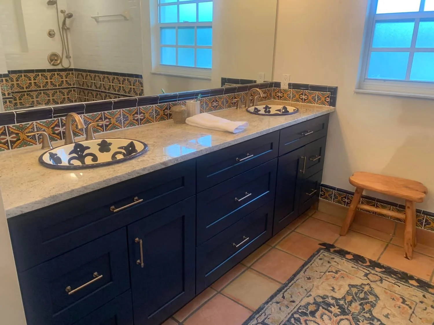 After - MichaelAngela stepped in, hand-painted authentic Spanish tiles, navy vanities, elegant arches - pure, warm, vintage soul. 