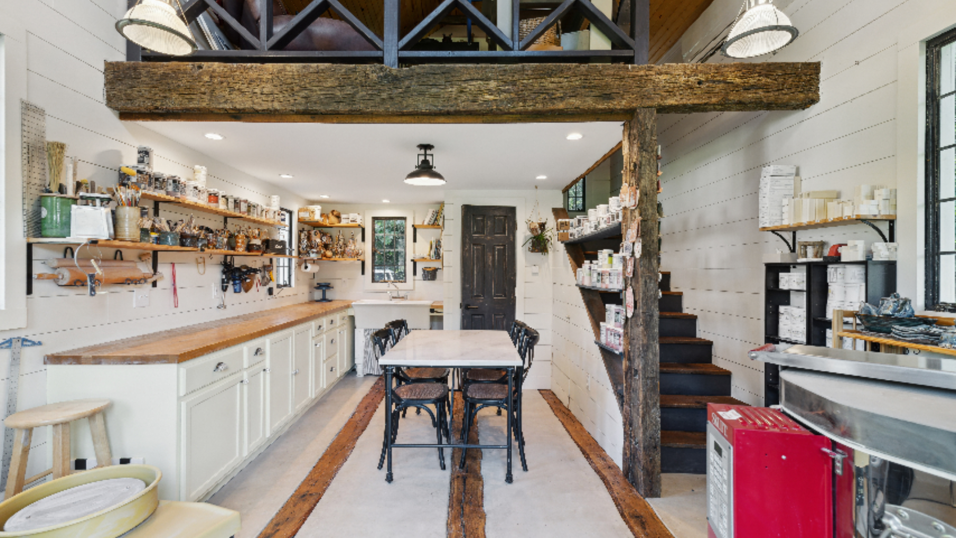 1890 Granary Barn Conversion - This reimagined granary barn now serves as a pottery studio with writer's quarters above, its soaring shiplap walls and reclaimed wood beams preserving the building's original 1890's character. A vintage staircase leads