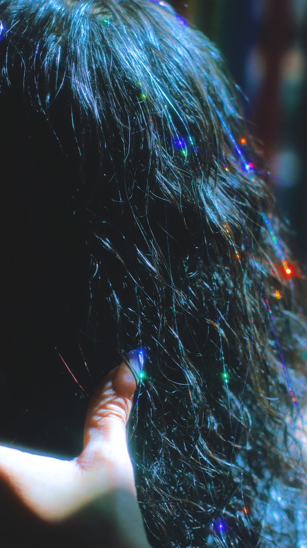 Rainbow hair tinsel strands in curly hair