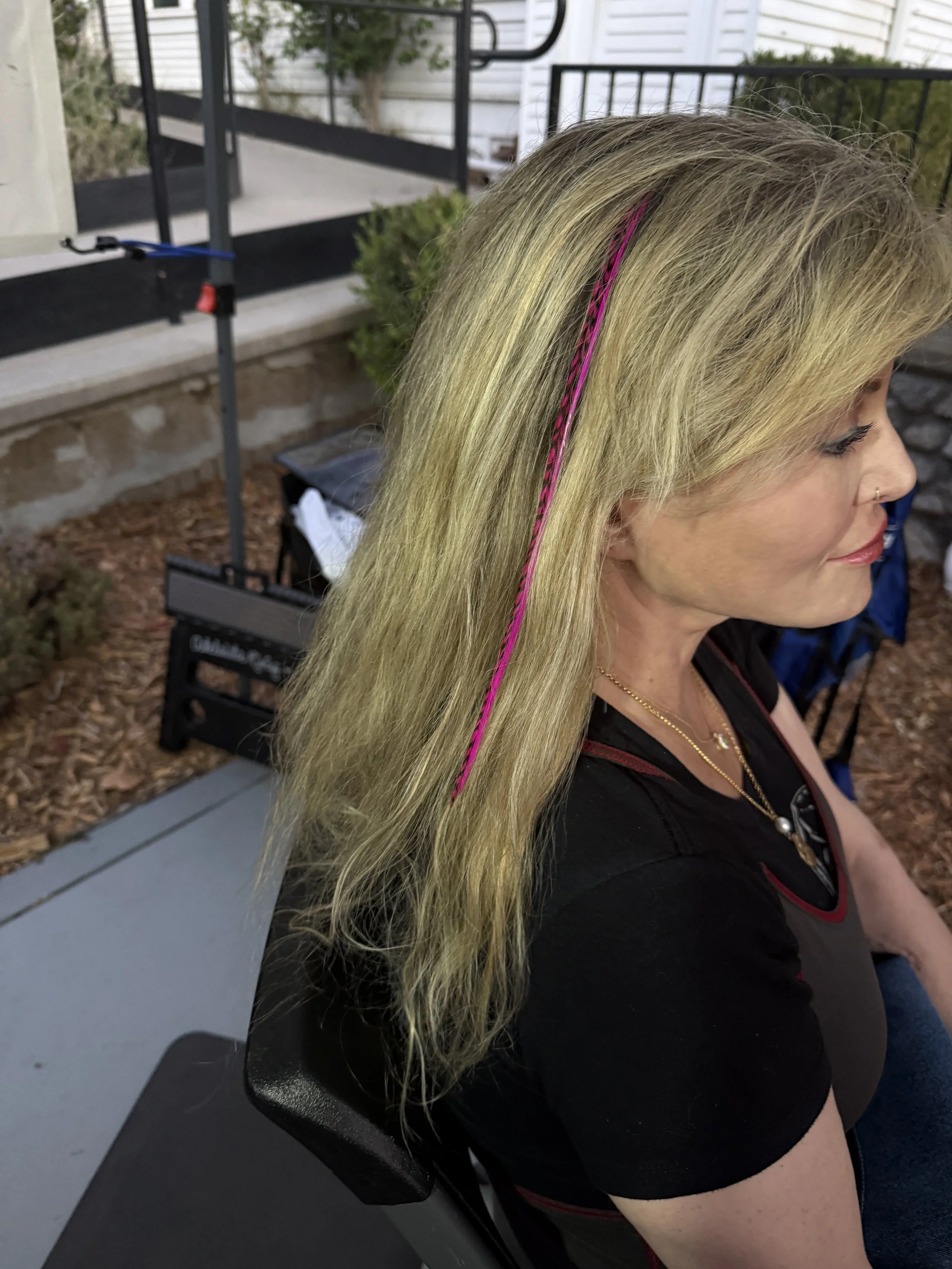 bright hair feathers in blonde hair on older woman
