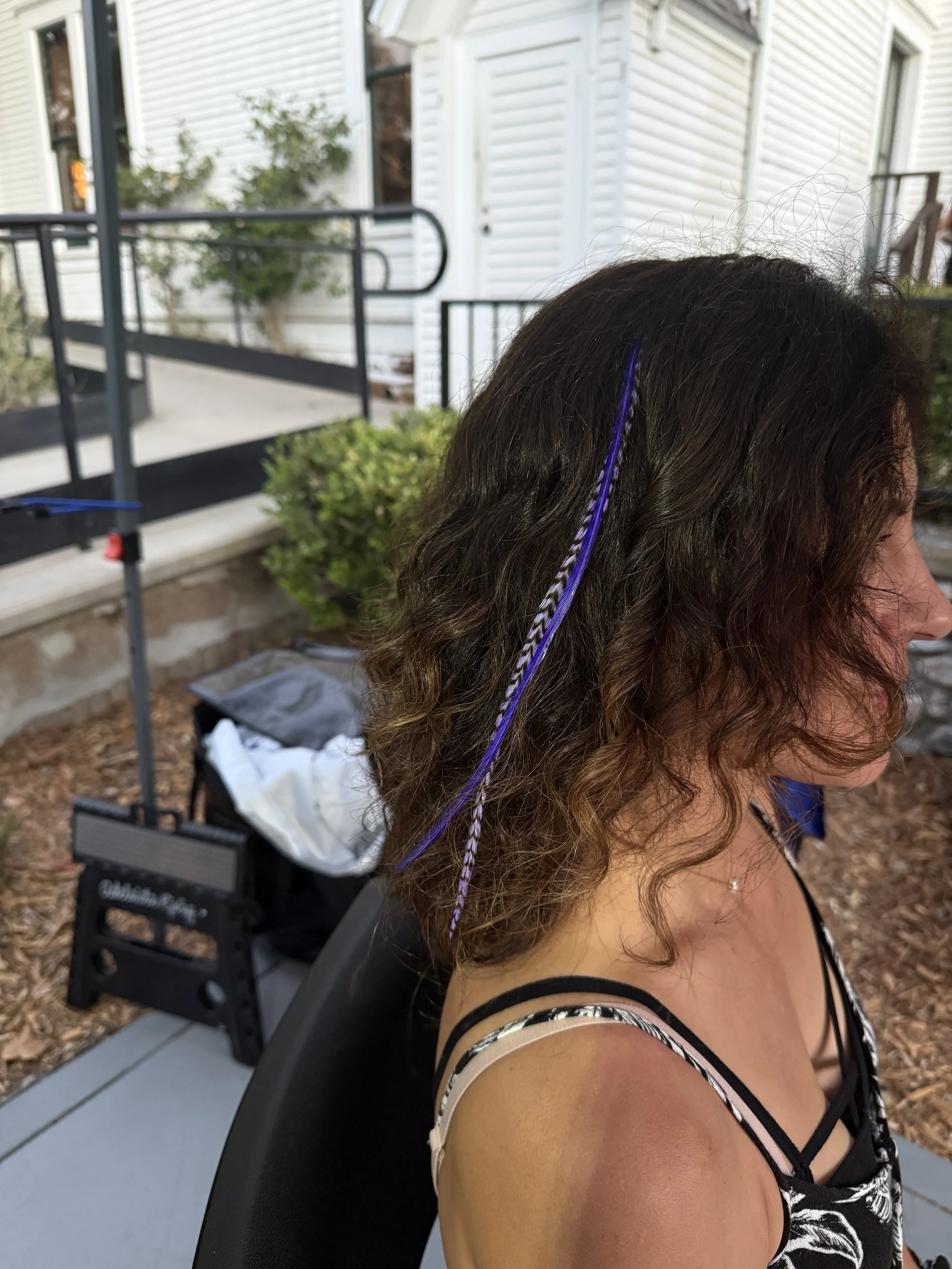 purple and light purple feather hair extensions in curly hair