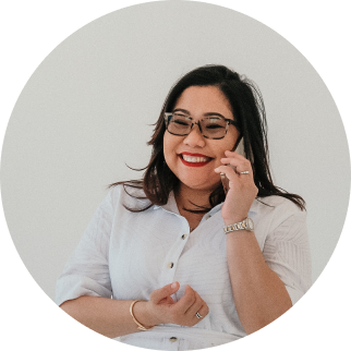 Woman smiling, wearing glasses, talking on the phone, white long-sleeve shirt