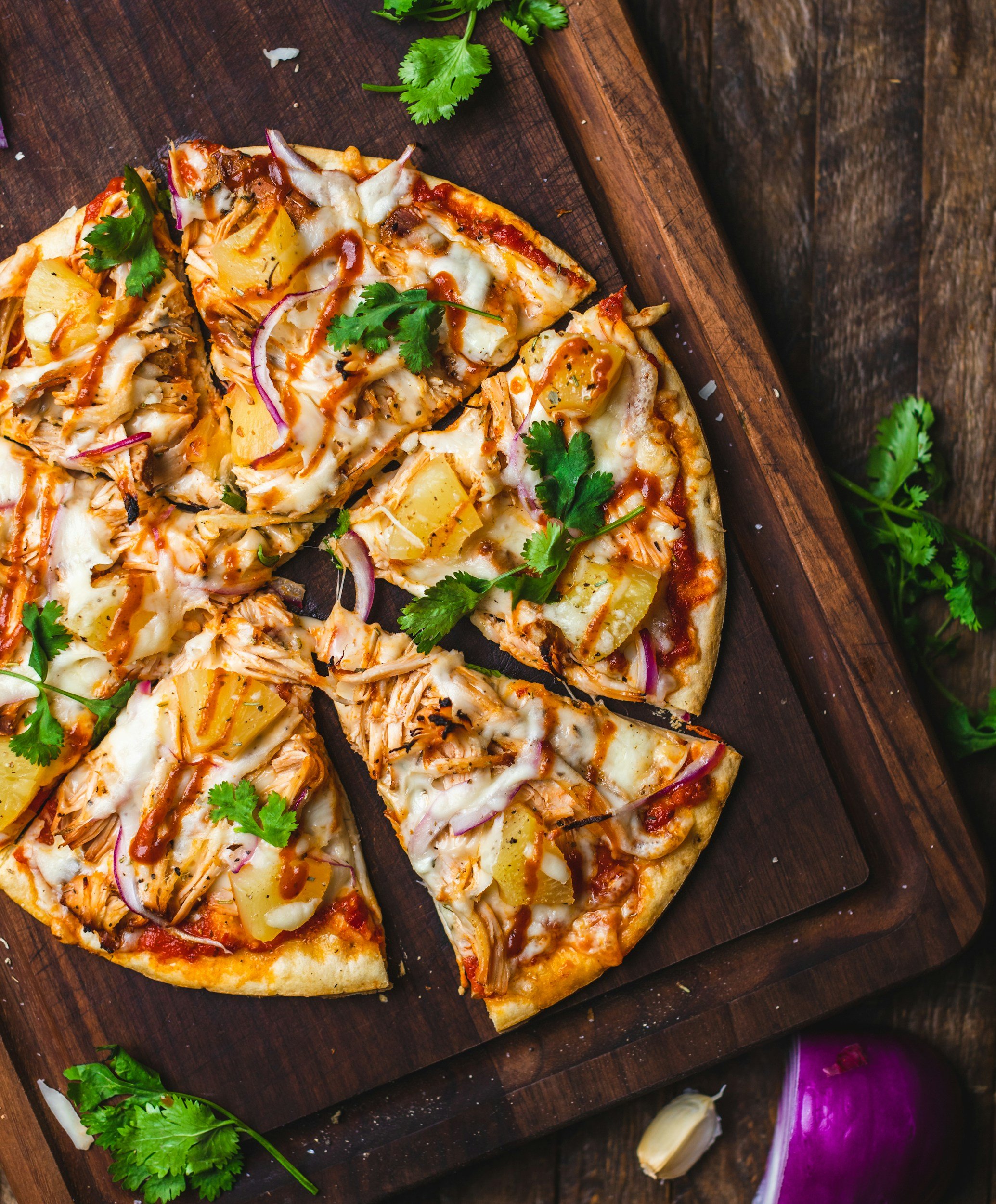Close-up of a wooden table with a pizza on it.