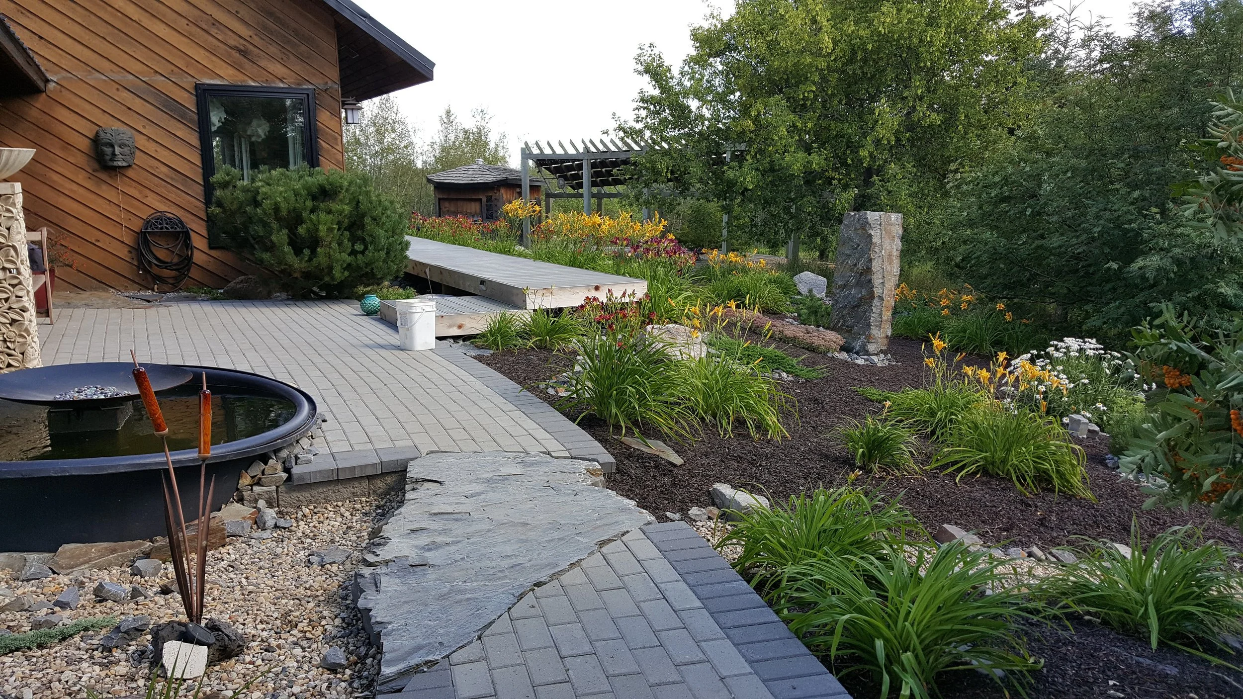 my acreage yard in SK - flagstone, patios, an obelisk, so many ponds including a converted swimming pool with stone bridge. These pics represent years of work. I miss my oasis. 