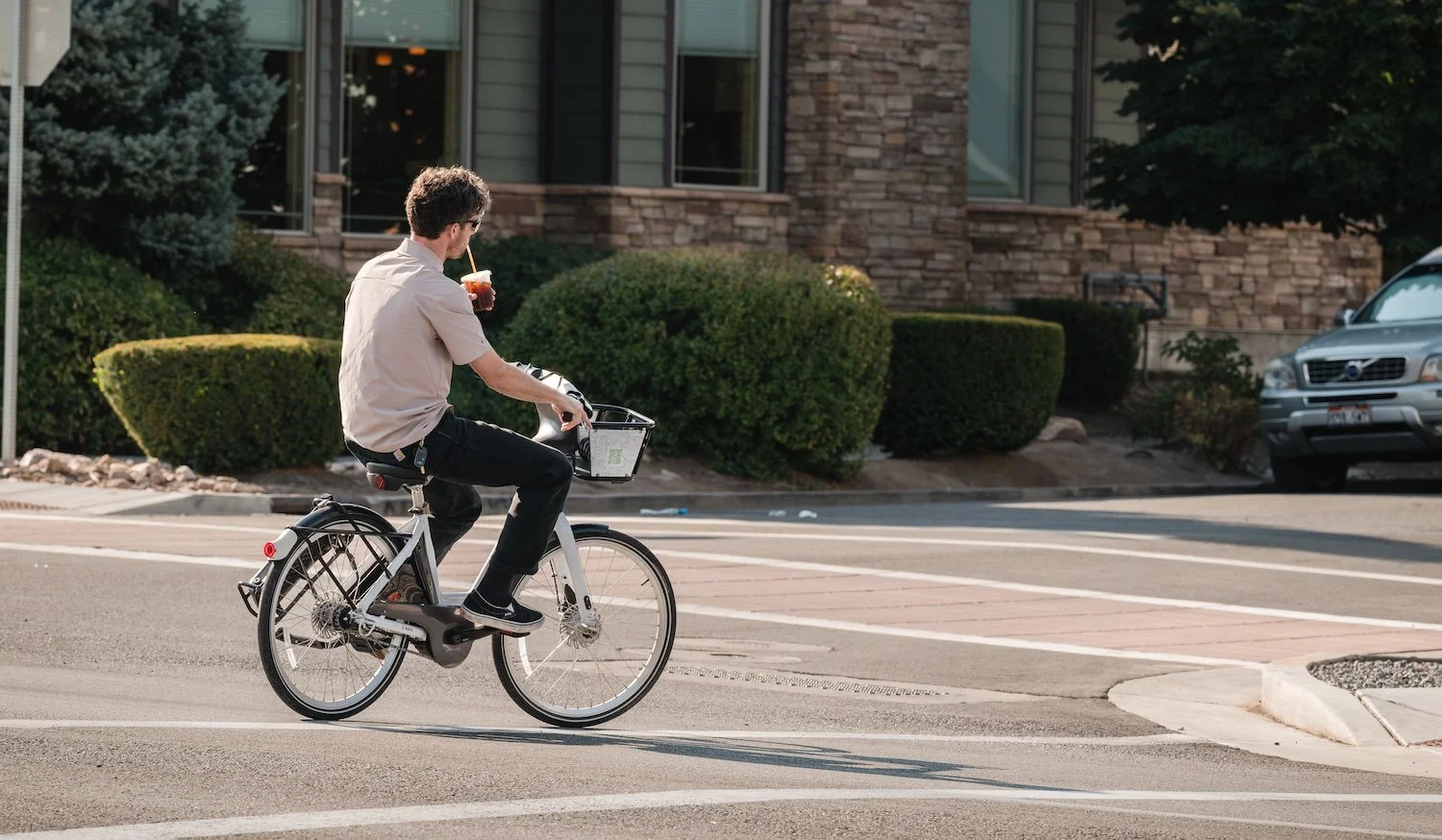 Guy riding GreenBike while sipping on a coffee drink