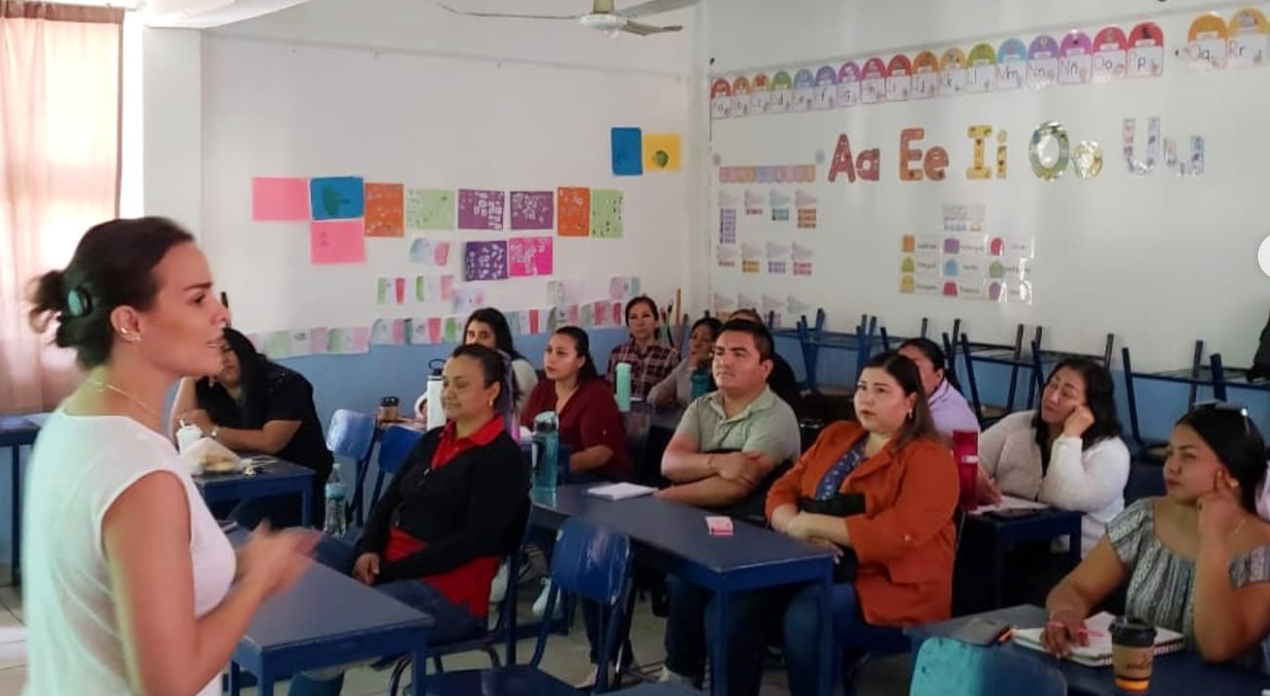Montse impartiendo un taller a un grupo de docentes de una escuela.