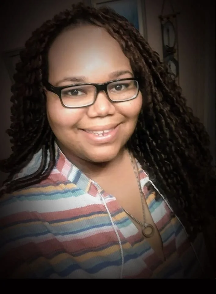 A selfie by Dontea'u wearing a pastel-banded shirt. The photo has a strong dark vignette.