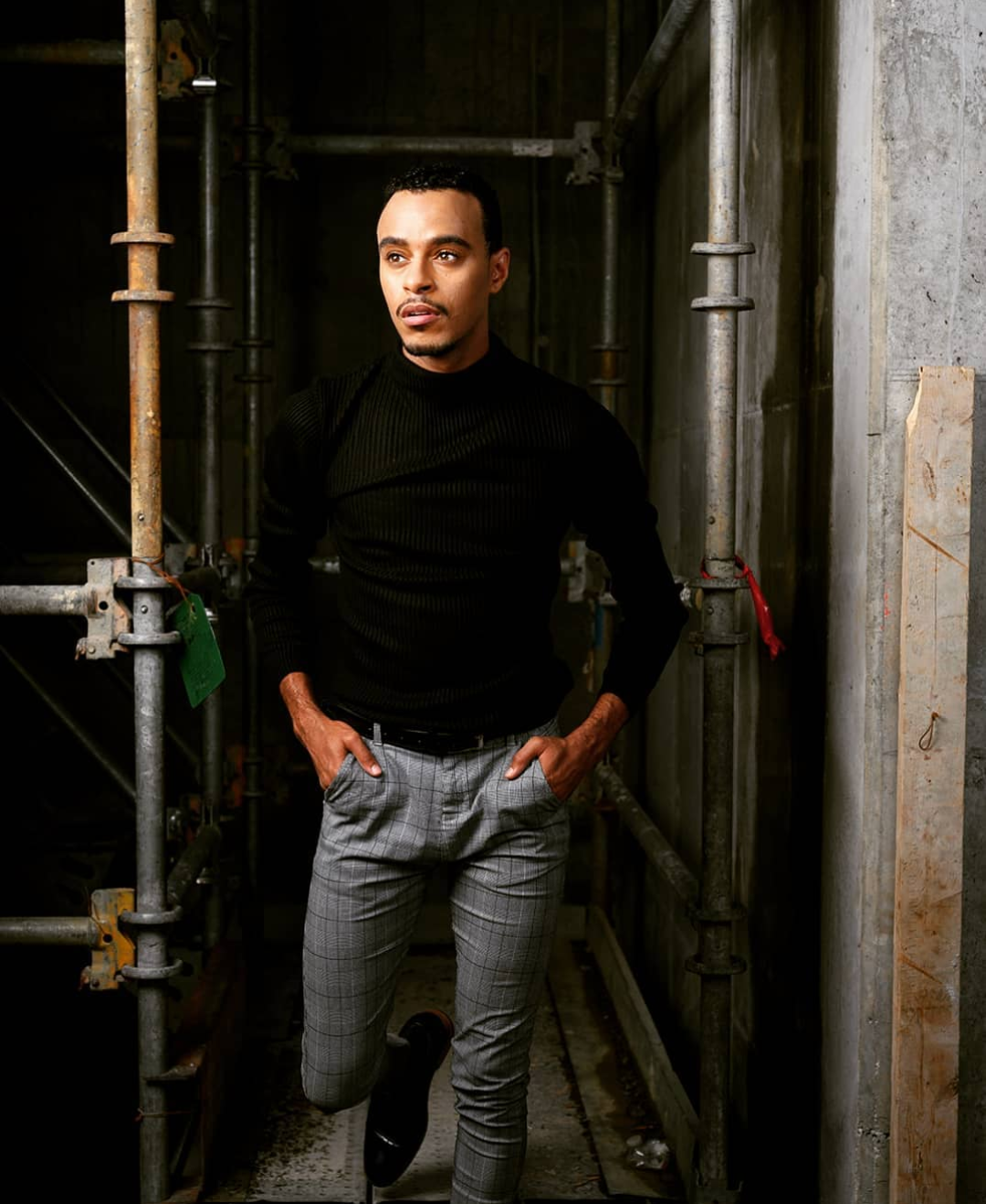 A photo of Edward wearing a black sweater in an industrial space.