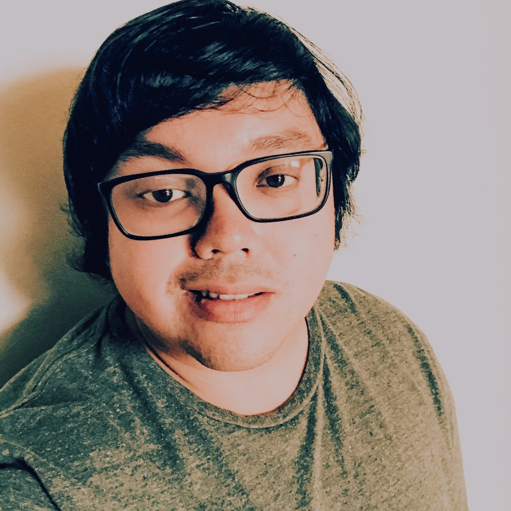 A photo of Joe taking a selfie against a blank wall.