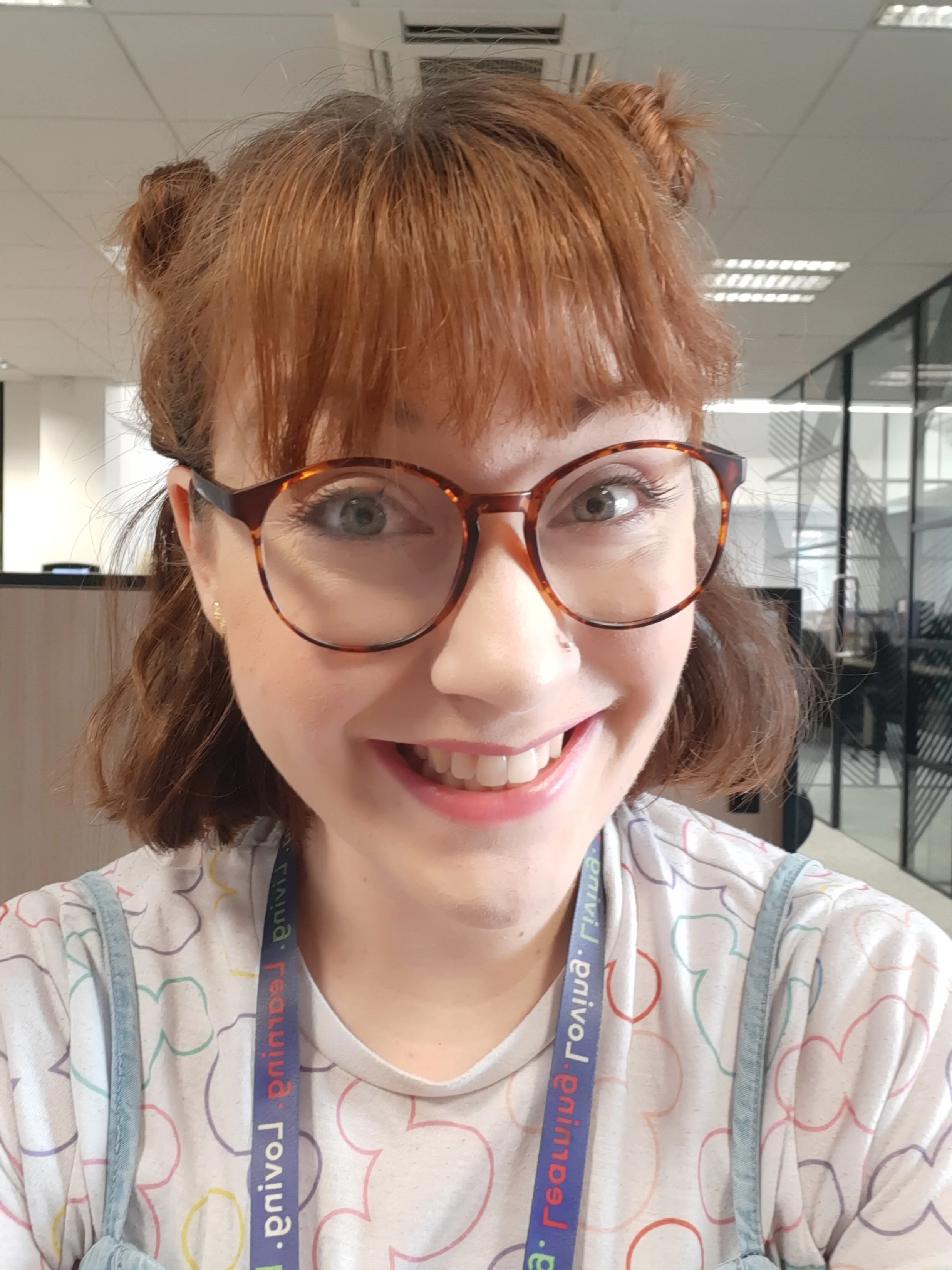 A photo of taking a selfie with a lanyard around her neck.
