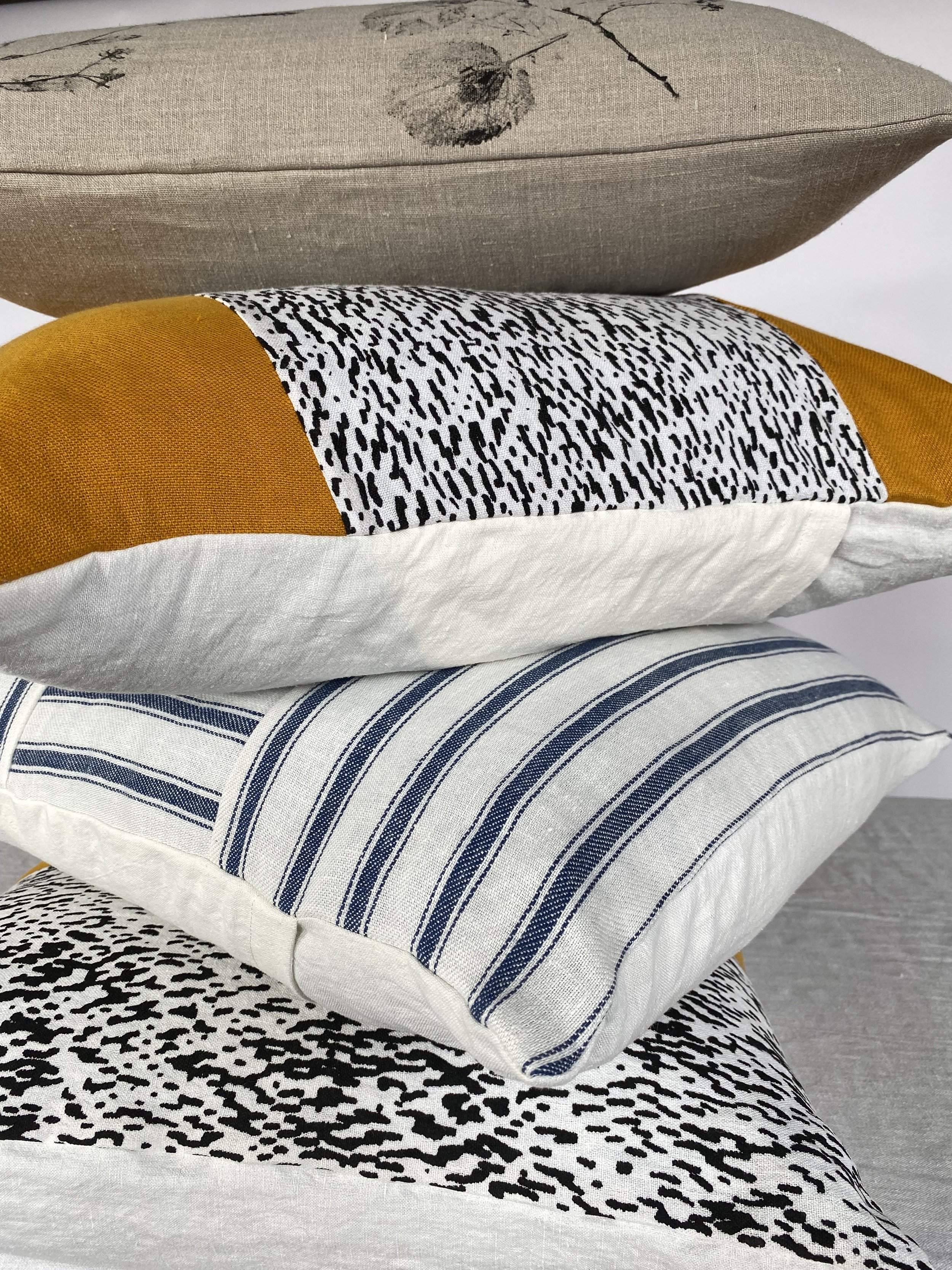 A photo of decorative cushions with various patterns; including polka dots, stripes, and abstract designs.