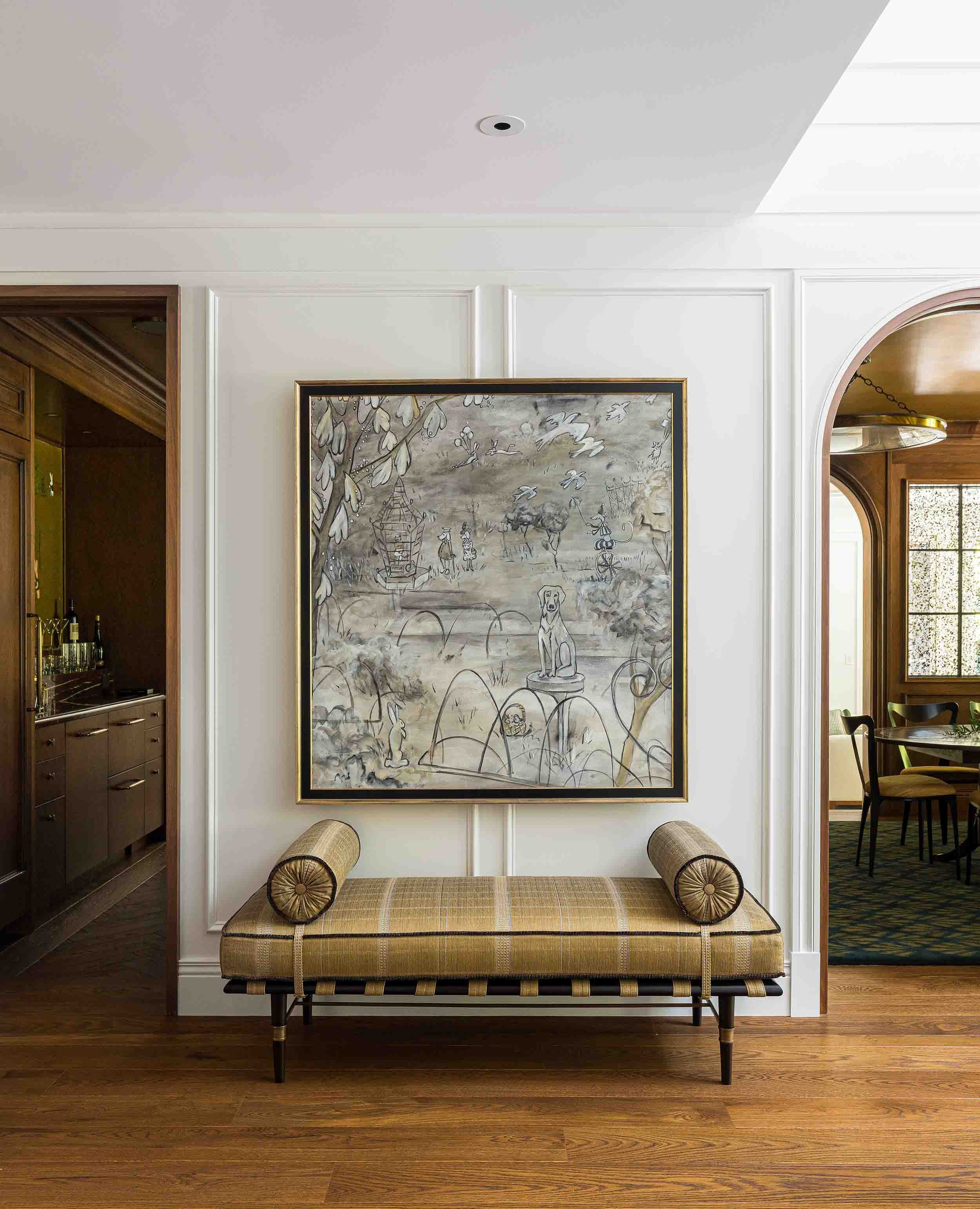 Paneled hallway with custom large-scale artwork, upholstered daybed, and arched doorways leading to bar and dining rooms in
Norman Charles Construction home.