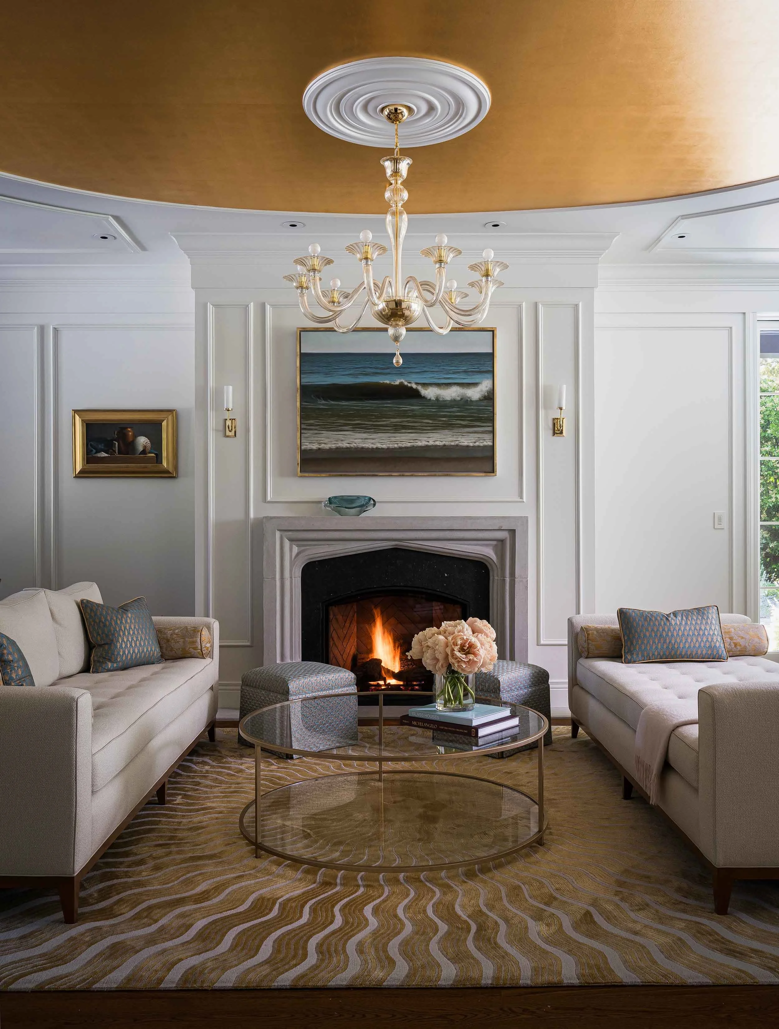 Living room with circular gold leaf dome ceiling, marble fireplace surround, Murano glass chandelier, and tufted furnishings