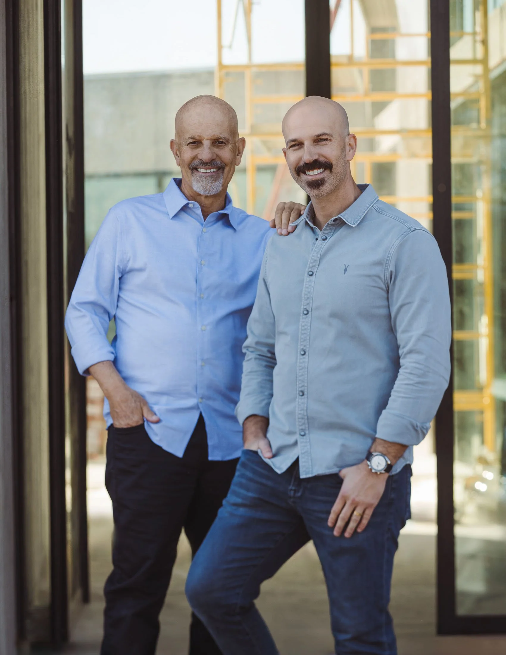 Norman and Nathan Charles of Norman Charles Construction standing at a residential custom home project site.