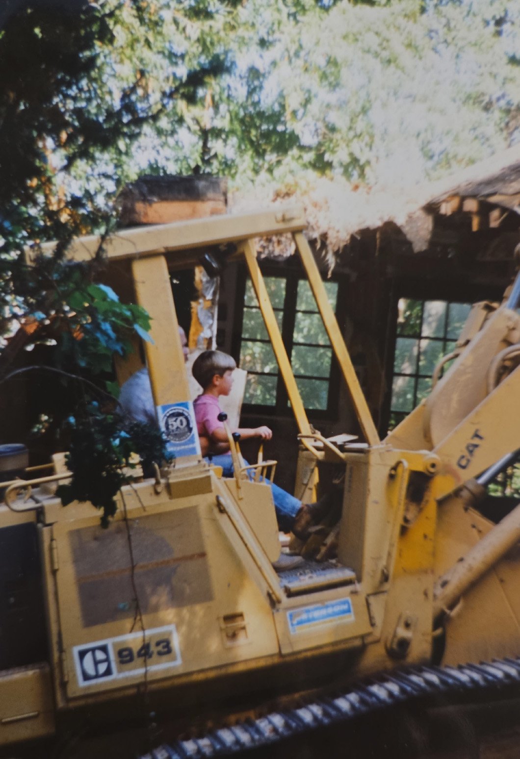 Nathan Charles as a child on construction equipment, representing two generations behind Norman Charles Construction.
