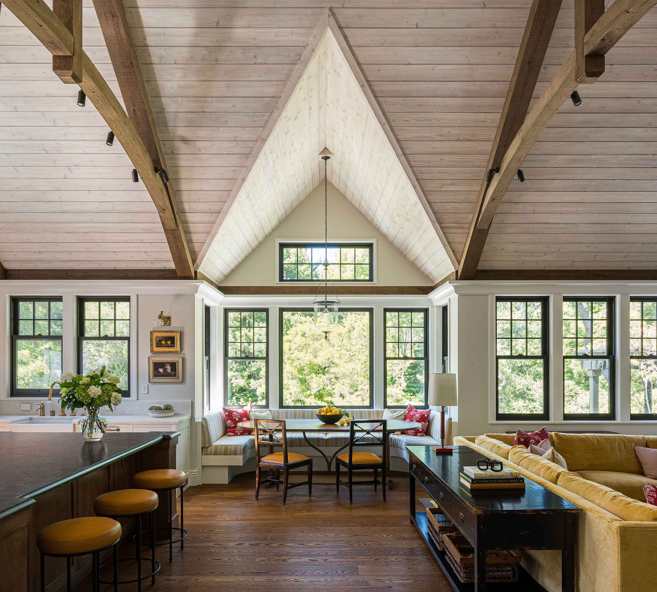 Open-plan great room with soaring timber-trussed vaulted ceiling connecting kitchen, breakfast nook, and living areas in Norman
Charles Construction custom home.
