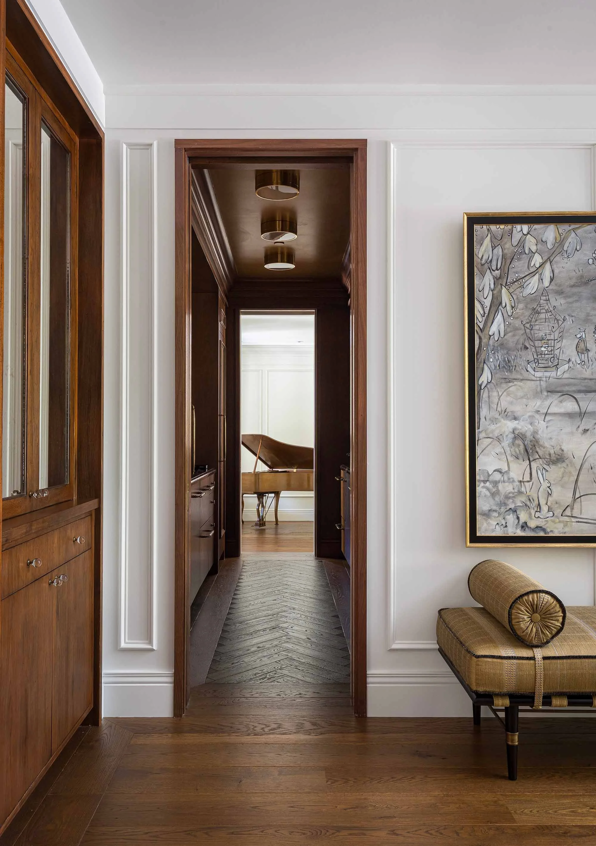 Hallway with walnut millwork doorway and herringbone floor corridor leading to music room with grand piano