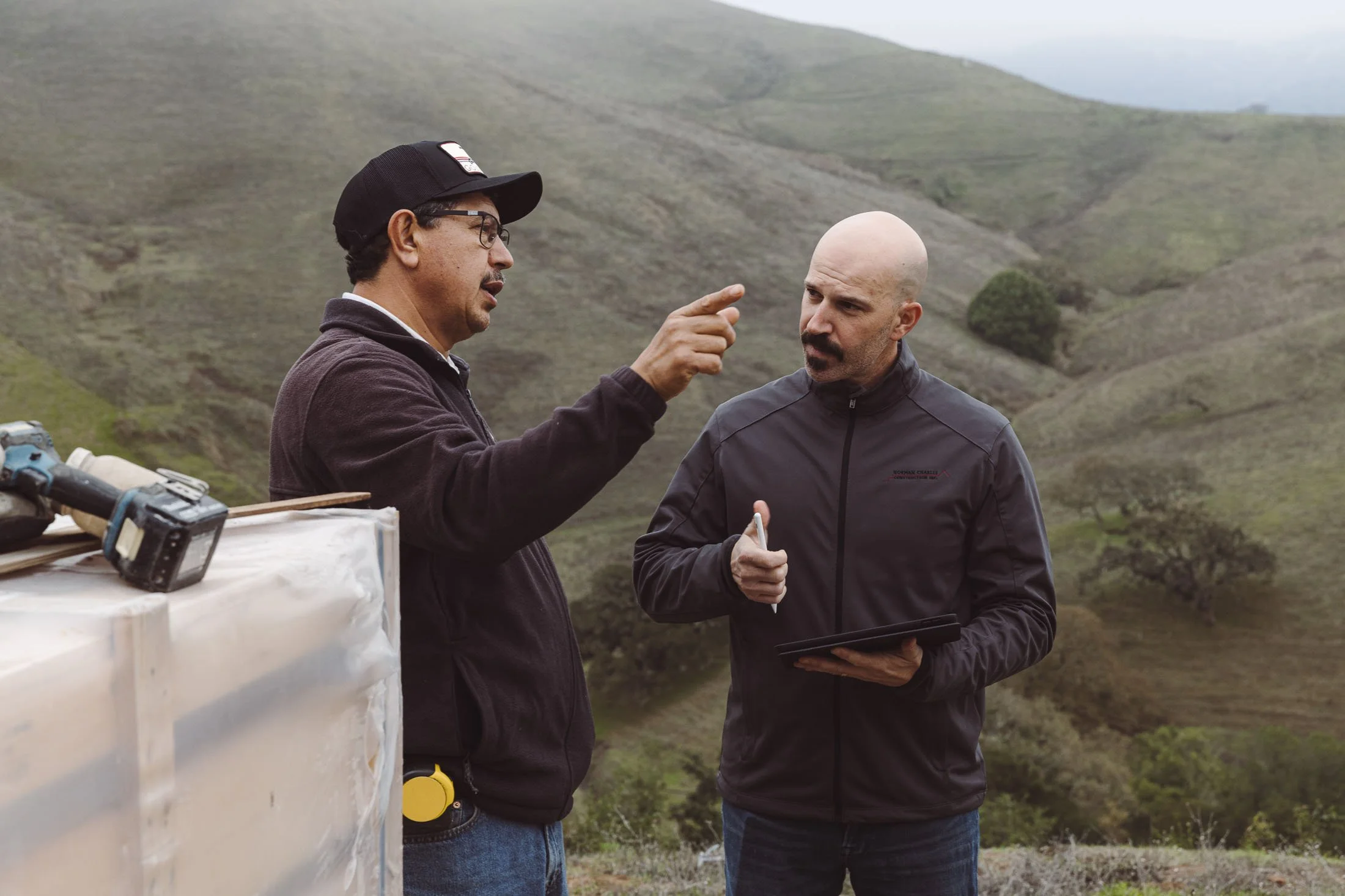 Nathan Charles reviewing plans with a team member on a residential custom home job site.