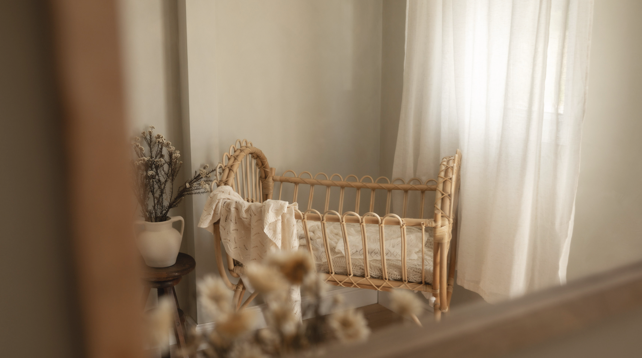 Natural light in Little River's newborn photography studio with a bamboo crib and neutral styling.