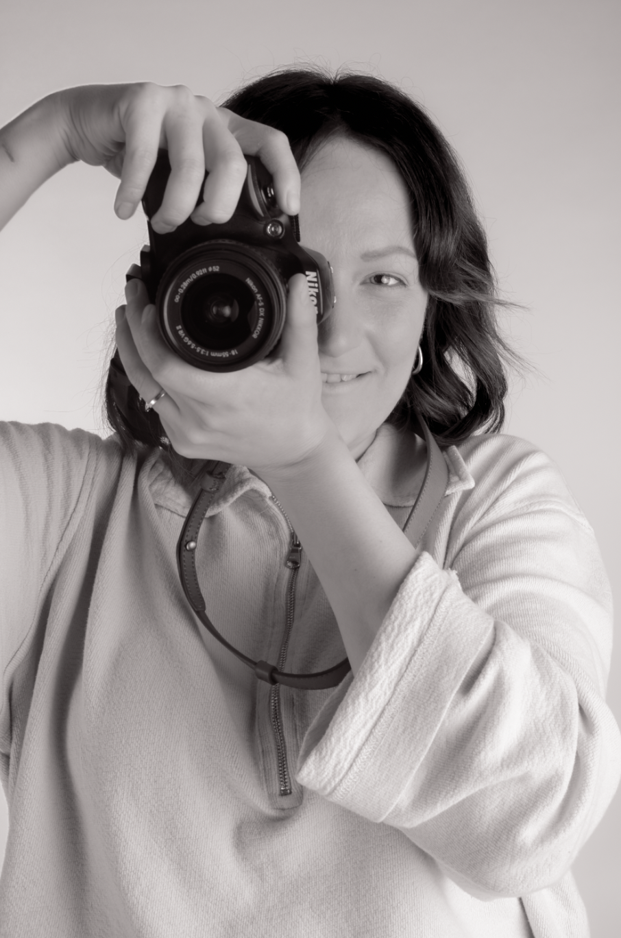 Portrait of Becky, the photographer behind Little River Photography, holding a camera.