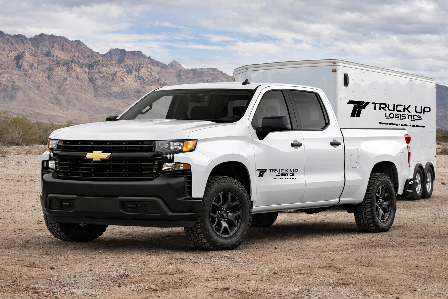A white Chevrolet pickup truck with a cargo trailer attached, parked on a desert landscape with mountains in the background. The truck and trailer display the "Truck Up Logistics" logo.